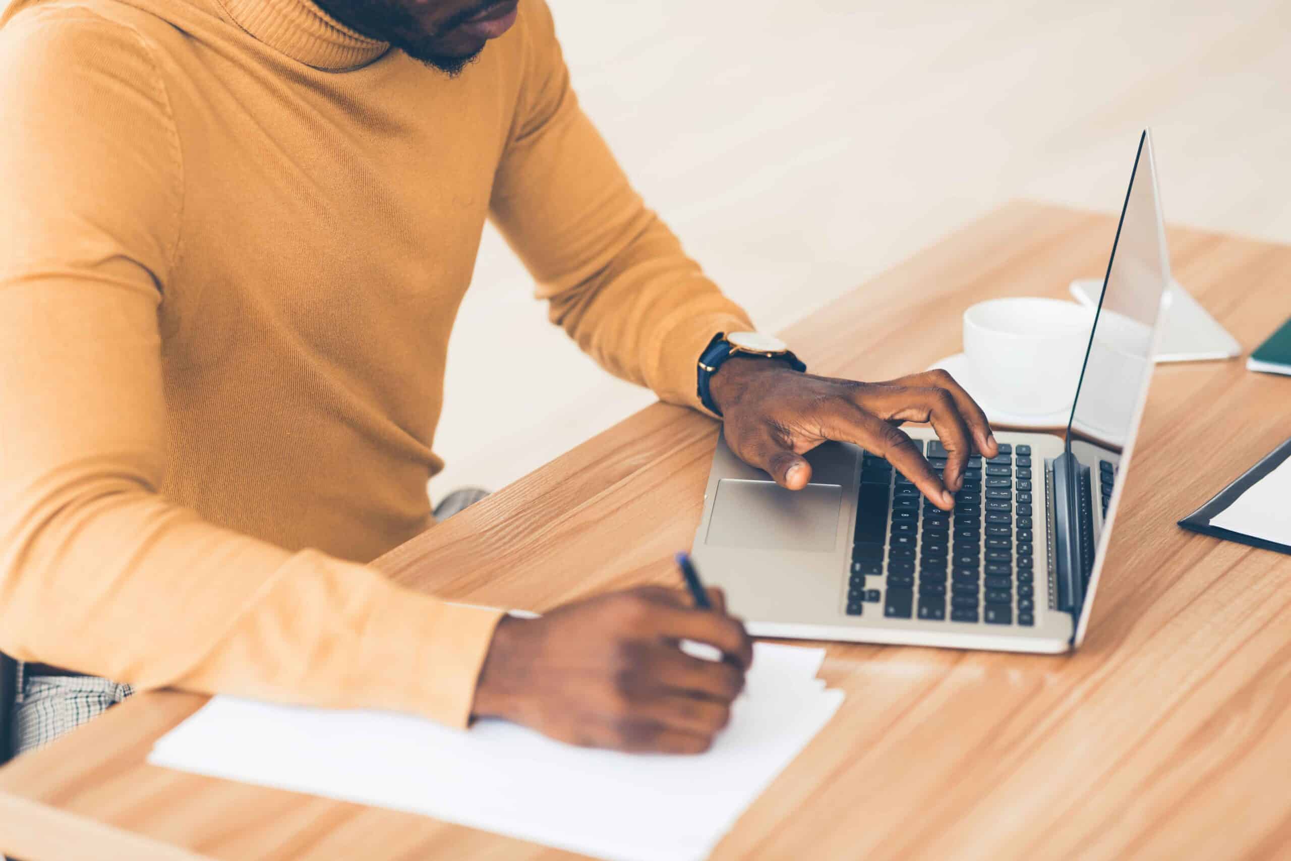 SEO-writing-tips person SEO wiring on laptop and paper